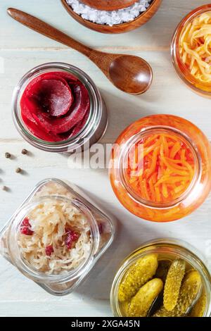 Probiotische Lebensmittel. Fermentierte Lebensmittel. Sauerkraut in Dosen, Karotten, Gurken und andere Konserven in Glasgläsern. Hausgemachte vegane Küche auf rustikalem Holz Stockfoto