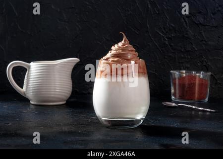 Dalgona kalter Kaffee mit Zutaten und Platz für Kopien auf schwarzem Schiefergrund Stockfoto