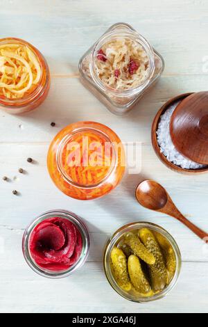 Fermentierte Lebensmittel. Gemüse aus der Dose. Eingelegte Karotten, Rüben, Sauerkohl und andere organische Konserven in Glasgläsern, oben flach auf einem rustikalen Schuss Stockfoto