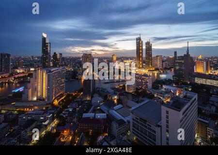 Bangkok, Thailand: Dramatischer Sonnenuntergang über der Skyline von Bangkok entlang des Flusses Chao Praya in der thailändischen Hauptstadt. Stockfoto