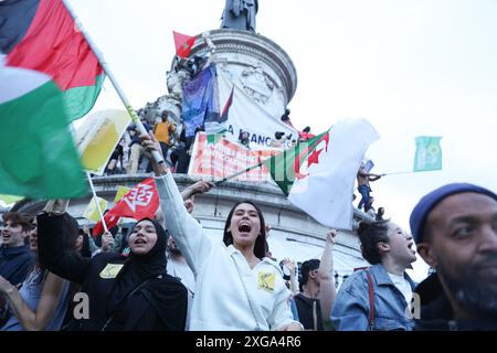 Zwei Demonstranten schreien mit Freude, den Sieg der neuen Volksfront mit palästinensischer und algerischer Flagge zu feiern. Die Teilnehmer trafen sich während einer Wahlkampfveranstaltung nach dem ersten Ergebnis der zweiten Wahlrunde der französischen Parlamentswahlen am Place de la Republique in Paris am 7. Juli 2024. Eine lose Allianz französischer linker Parteien, die sich für Schnellwahlen zusammengeschlossen hatten, war auf dem Weg, der größte Parlamentsblock zu werden und die extreme Rechte zu besiegen, wie schockierte Ergebnisse zeigen. Foto: Christophe Michel/ABACAPRESS. COM Republic Platz für den Sieg der ne Stockfoto