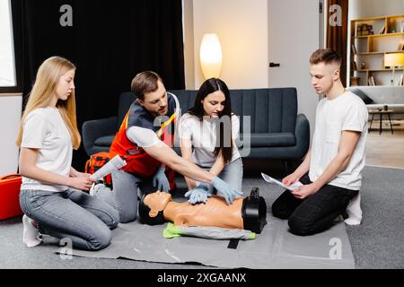 Gruppe von Personen, die lernen, wie man mit den Dummies während des Trainings im Innenbereich erste-Hilfe-Herzkompressionen durchführt. Stockfoto