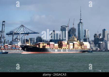 Auckland, Neuseeland - 23. Juli 2023: Ein Containerschiff verlässt den Hafen von Auckland in der größten Stadt Neuseelands mit dem CBD-Himmel Stockfoto