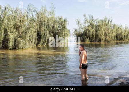 Wuhan, China. Juli 2024. Ein Mann steht im überfluteten Hankou Riverbank Park des Yangtze Flusses. Die Wasserstände in Abschnitten des mittleren und unteren Flusses des Yangtze-Flusses - Chinas längster Fluss - unterhalb der Mündung des Dongting-Sees, haben laut dem Ministerium für Wasserressourcen die Warnmarke überschritten. (Foto: Ren Yong/SOPA Images/SIPA USA) Credit: SIPA USA/Alamy Live News Stockfoto