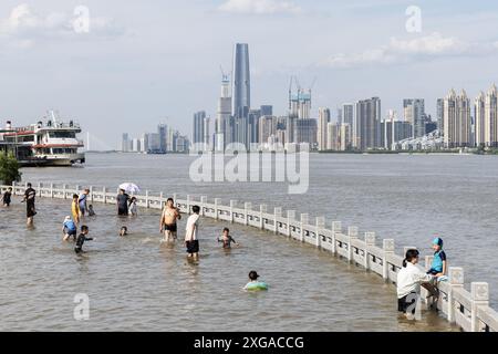 Wuhan, China. Juli 2024. Die Menschen spielen im überfluteten Hankou Riverbank Park am Yangtze. Die Wasserstände in Abschnitten des mittleren und unteren Flusses des Yangtze-Flusses - Chinas längster Fluss - unterhalb der Mündung des Dongting-Sees, haben laut dem Ministerium für Wasserressourcen die Warnmarke überschritten. (Foto: Ren Yong/SOPA Images/SIPA USA) Credit: SIPA USA/Alamy Live News Stockfoto