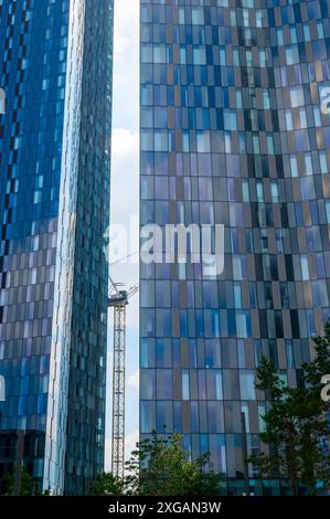 Die Türme am Deansgate Place, Castlefield, Manchester, neben dem Kanalbecken an einem sonnigen Juni-Tag mit blauem Himmel. Glänzende Fenster wie Schlangenhaut. Stockfoto