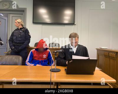 Kiel, Deutschland. Juli 2024. Der Angeklagte (l) sitzt neben seinem Verteidiger Maximilian Hermandung beim Mordprozess in einem Saal des Amtsgerichts Kiel. Der Angeklagte muss wegen der tödlichen Schießerei im Kieler Stadtteil Gaarden im Juni 2022 erneut vor Gericht gestellt werden, weil eine Berufung der Staatsanwaltschaft und der gemeinsamen Kläger gegen eine 12-jährige Totschlag-Verurteilung erfolgreich war. André Klohn/dpa - ACHTUNG: Person(en) wurde/wurden aus rechtlichen Gründen pixeliert/dpa/Alamy Live News Stockfoto