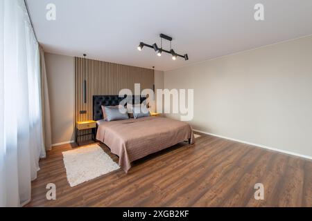 Luxuriöses Hauptschlafzimmer innen, modernes Haus, schöne Innenräume, großes Schlafzimmer. Weißer Teppich auf dem Boden. Stockfoto