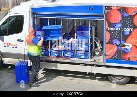 Der Fahrer von Tesco bringt leere blaue Kisten an den geparkten Lieferwagen zurück, nachdem er die wöchentliche Online-Bestellung des Kunden Essex England UK abgeschlossen hat Stockfoto