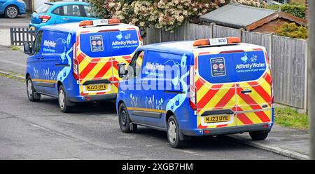 Zwei von einer Art Affinity Water Engineers Vans parkten in Dorfbewohnern Straßenbesatzungen, die sich um die Versorgungsprobleme der Haushalte kümmern Essex England Großbritannien Stockfoto