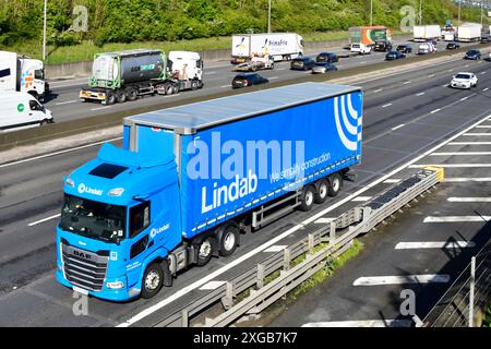 M25 Autobahn gegen Uhrzeigersinn befahrene LKW Verkehr klarere Straße für blaue DAF lkw LKW Lindab Baustoffgeschäft Essex England UK Stockfoto