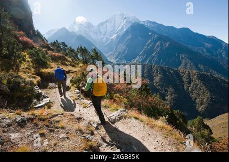 Ein Mann und eine Frau mittleren Alters genießen eine moderate Wanderung in der unteren Region der Wanderung nach mt. everest Basislager. Stockfoto