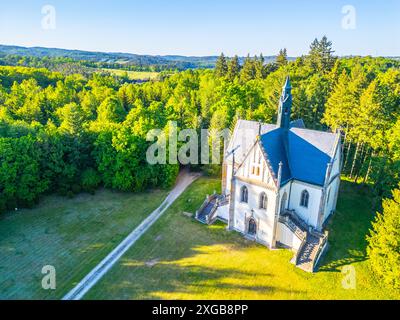 Das Schwarzenberg-Gewölbe ist eine gotische Kapelle in den Wäldern von Orlik nad Vltavou in Tschechien, mit üppigem Grün und einem Pfad, der zu seinem Eingang führt. Stockfoto