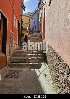 Steile Treppe in der Gasse von Vernazza, Cinque Terre, Italien. Farbenfrohe Gebäude. Vertikales Foto. Stockfoto