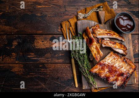 Gegrilltes Schweinefleisch, Baby-Rücken, Spare Rippchen auf einem Holzbrett. Hölzerner Hintergrund. Draufsicht. Kopierbereich Stockfoto