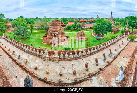 Panorama des Wat Yai Chai Mongkhon mit Statuen von Buddha, Ubosot, geschnitzten Chedis, Schreinen und grünem Garten, Ayutthaya, Thailand Stockfoto