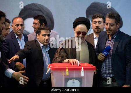 Teheran, Iran. Juli 2024. Der ehemalige iranische Präsident Seyyed Mohammad Khatami wirft seine Stimme bei der Präsidentschaftswahl vor einem Porträt des iranischen Revolutionsführers Ayatollah Ruhollah Khomeini und seines Sohnes am Freitag, den 5. Juli 2024, in Jamaran Hussainiya ab. Die Iraner begannen am Freitag bei einer Stichwahl zu wählen, um den verstorbenen Präsidenten Ebrahim Raisi zu ersetzen, der letzten Monat bei einem Hubschrauberabsturz ums Leben kam. (Foto: Sobhan Farajvan/Pacific Press/SIPA USA) Credit: SIPA USA/Alamy Live News Stockfoto