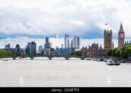 London mit roten Londoner Bussen über die Westminster Bridge. Vauxhall und Nine Elms Tower Blocks Skyline hinter Elizabeth Tower und Palace of Westminster Stockfoto