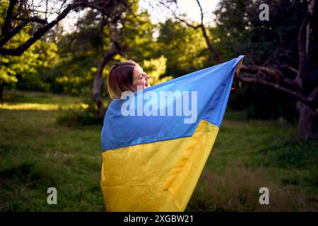 Frau in rotem Kleid läuft mit der Flagge der Ukraine Stockfoto
