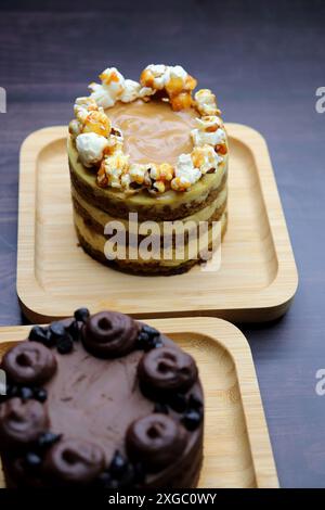 Verschiedene Mini-Kuchen der Saison. Haselnuss, Oper, gesalzenes Karamell und Doppelschokolade. Unendliche Vielfalt, einfaches Servieren, feuchte Schichten, reichhaltige Zuckerguss. Stockfoto