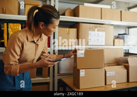 Frau Überprüft Den Barcode Auf Dem Paket Mit Dem Smartphone Stockfoto