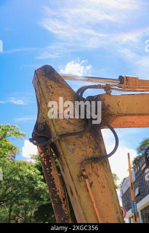 Verschlissener gelber Baggerlöffel bei sonnigem Tag Stockfoto