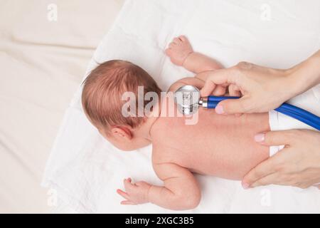 Arzt untersucht Neugeborenes mit Stethoskop im Rahmen einer Gesundheitsprüfung Stockfoto