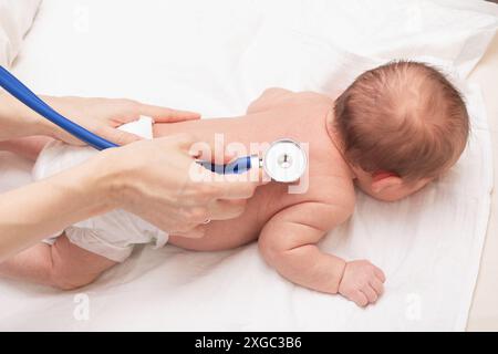Arzt untersucht Neugeborenes mit Stethoskop im Rahmen einer Gesundheitsprüfung Stockfoto