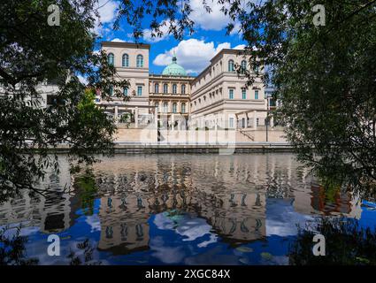 Potsdam, Deutschland. Juli 2024. Bei sonnigem Wetter spiegelt sich die Wasserseite des Barberini Museums im Wasser der Alten Fahrt, die entlang der Freundschaftsinsel verläuft. Quelle: Soeren Stache/dpa/ZB/dpa/Alamy Live News Stockfoto