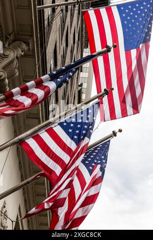 Amerikanische Flaggen fliegen vor einem Gebäude in New York City Stockfoto