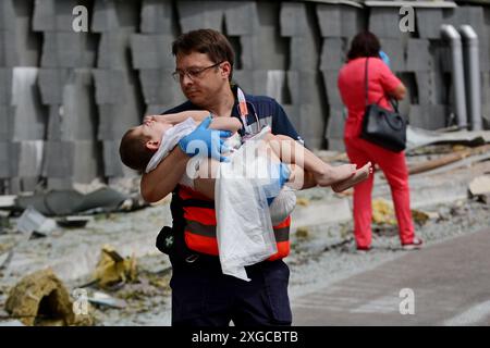 Kiew, Ukraine. Juli 2024. Ein Arzt bringt ein Kind aus der Okhmatdyt Children's Clinic Hospital, das nach einem Raketenangriff verletzt wurde. Am Morgen führte die russische Armee einen Raketenangriff auf die ukrainischen Städte Kiew, Dnipro, Kryvyi Rih, Slowiansk, Kramatorsk, mit mehr als 40 Raketen verschiedener Art. In Kiew wurden Wohngebäude, Infrastrukturanlagen und das Kinderkrankenhaus „Okhmatdyt“ beschädigt. Retter suchen weiterhin nach Menschen unter den Trümmern. Quelle: SOPA Images Limited/Alamy Live News Stockfoto