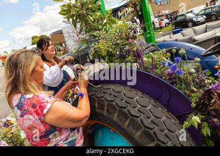 Harrogate, Großbritannien, 8. Juli 2024. 15 Blumenbauern aus allen Ecken von Yorkshire und dem Nordosten haben sich zusammengefunden, um lokal angebaute britische Blumen zu feiern. Vor der Eröffnung der ausverkauften Great Yoskhire Show 2024, die vom 9. Bis 12. Juli auf dem Yorkshire Showground in Harrogate, England, stattfindet, wird eine Blumenausstellung mit einem Vintage-Traktor abgeschlossen. Quelle: Thomas Holmes/Alamy Live News Stockfoto