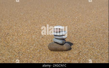 Kieselsteine, weiß und grau, auf dem Sand gestapelt Stockfoto