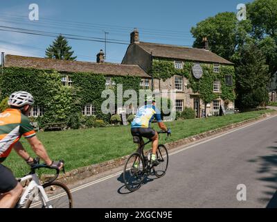 Die Lister Arms und Radfahrer in Malham Village in den Yorkshire Dales, North Yorkshire England Großbritannien - Radurlaub Stockfoto