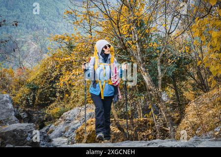 Kaukasische Frauen wandern auf einem Wanderweg im Freien, umgeben von herbstlicher Natur. Kalter Morgen und Reisen im Herbst ins Freie Stockfoto