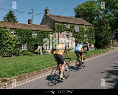 Die Lister Arms und Radfahrer in Malham Village in den Yorkshire Dales, North Yorkshire England Großbritannien - Radurlaub Stockfoto