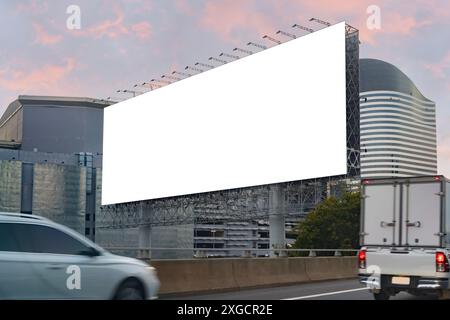 Großes horizontales Blanko-Schild auf einer Autobahn in Bangkok, Thailand. Verkehr und Himmel. Leere Werbetafel in der Dämmerung für Werbung, Beschneidungspfad. Stockfoto