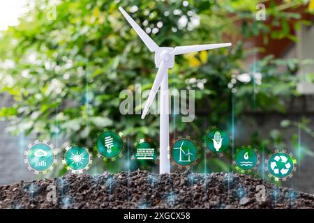 Umweltfreundliche Energie, Konzept für umweltfreundliche Energie. Die Glühbirne befindet sich auf dem Boden, und die Pflanzen wachsen mit einer Windturbine. Die Erzeugung erneuerbarer Energien ist von entscheidender Bedeutung Stockfoto