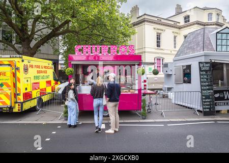 Junge Leute, die bei einem Churros-Verkäufer auf ihre Bestellung warten. Street Food-Verkäufer mit Kunden, die warten. Fast Food, Ernährung, Lebensstil oder Gesundheitskonzept Stockfoto