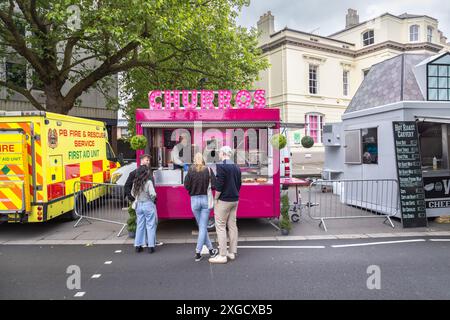 Junge Leute, die bei einem Churros-Verkäufer auf ihre Bestellung warten. Street Food-Verkäufer mit Kunden, die warten. Fast Food, Ernährung, Lebensstil oder Gesundheitskonzept Stockfoto