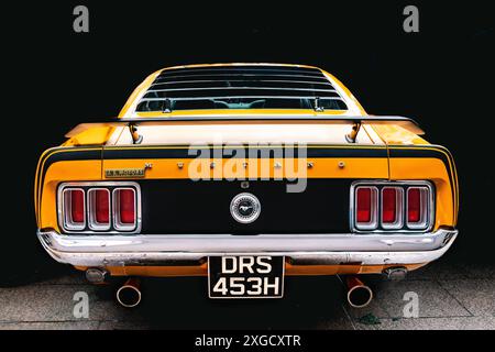 Rückansicht eines Ford Mustang aus den 1970er Jahren. Der Ford Mustang Mach 1 ist ein legendäres amerikanisches Muscle Car. Amerikanische Motorenherstellung. Greifer orange. Stockfoto