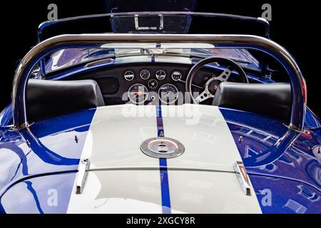 Rückansicht eines Fahrzeugs im Stil eines AC Cobra. Eine schlanke Perspektive durch das Cockpit, die klassische Kurven, den Vintage-Charme und die Renntradition einfängt. Stockfoto