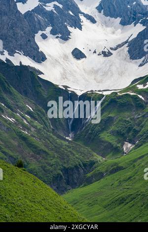 Wasserfall, Schneeschmelze in den Vorarlberger Alpen, Schnee auf den Bergen schmilzt und fällt in Bäche und Wasserfälle ins Tal, Schneefelder Stockfoto