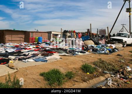 Baracken in der Slum Township in Südafrika, Gebrauchtkleidermarkt am Straßenrand Stockfoto