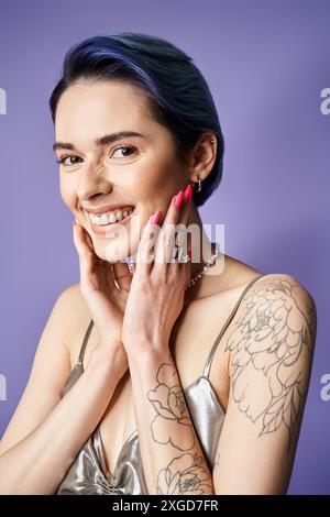 Eine stilvolle junge Frau mit Tätowierungen auf den Armen zeigt eine selbstbewusste Pose und zeigt ihre einzigartige Körperkunst. Stockfoto