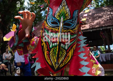 Ein Teilnehmer, der eine Geistermaske trägt und in Kostümen gekleidet ist, nimmt an dem Festival Teil. Das Phi Ta Khon Geisterfest in Thailand, das im Bezirk Dan Sai in der Provinz Loei im Nordosten Thailands stattfand und typischerweise an einem Freitag am ersten Wochenende nach dem sechsten Vollmond des Jahres beginnt. Diese Tradition wird jedes Jahr eingehalten, um den Beginn der Regenzeit zu markieren. Im Einklang mit dem buddhistischen Glauben werden die Dorfbewohner die Geister der Toten tragen, die zum Leben zurückkehren und dem Herrn Buddha in die Stadt folgen. (Foto: Peerapon Stockfoto