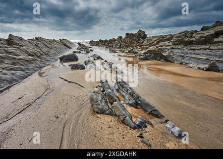 Ein felsiges Ufer bei Ebbe und unter grauem Himmel; am Welcombe Mouth, Hartland, Nord-Devon, England, Vereinigtes Königreich, Europa Stockfoto