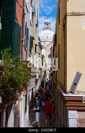 Eine enge, überfüllte Gasse führt zur barocken Basilika de Santa Maria Della Salute (St. Maria der Gesundheit), die 1681 geweiht wurde, Venedig, UNESCO Wor Stockfoto