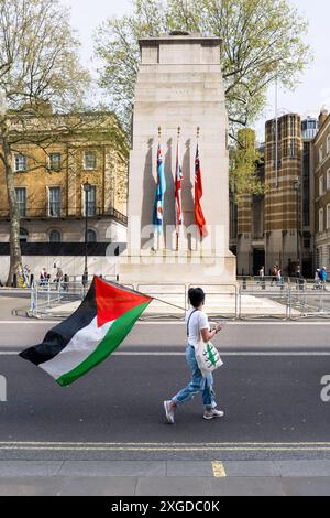 Frau mit palästinensischer Flagge am Cenotaph in Whitehall, London. In der Nähe fand ein palästinensischer solidaritätsmarsch statt. Stockfoto