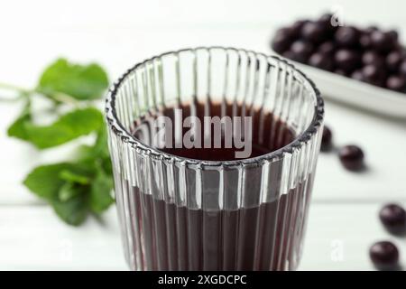 Köstlicher Acai-Saft im Glas auf weißem Tisch, Nahaufnahme Stockfoto